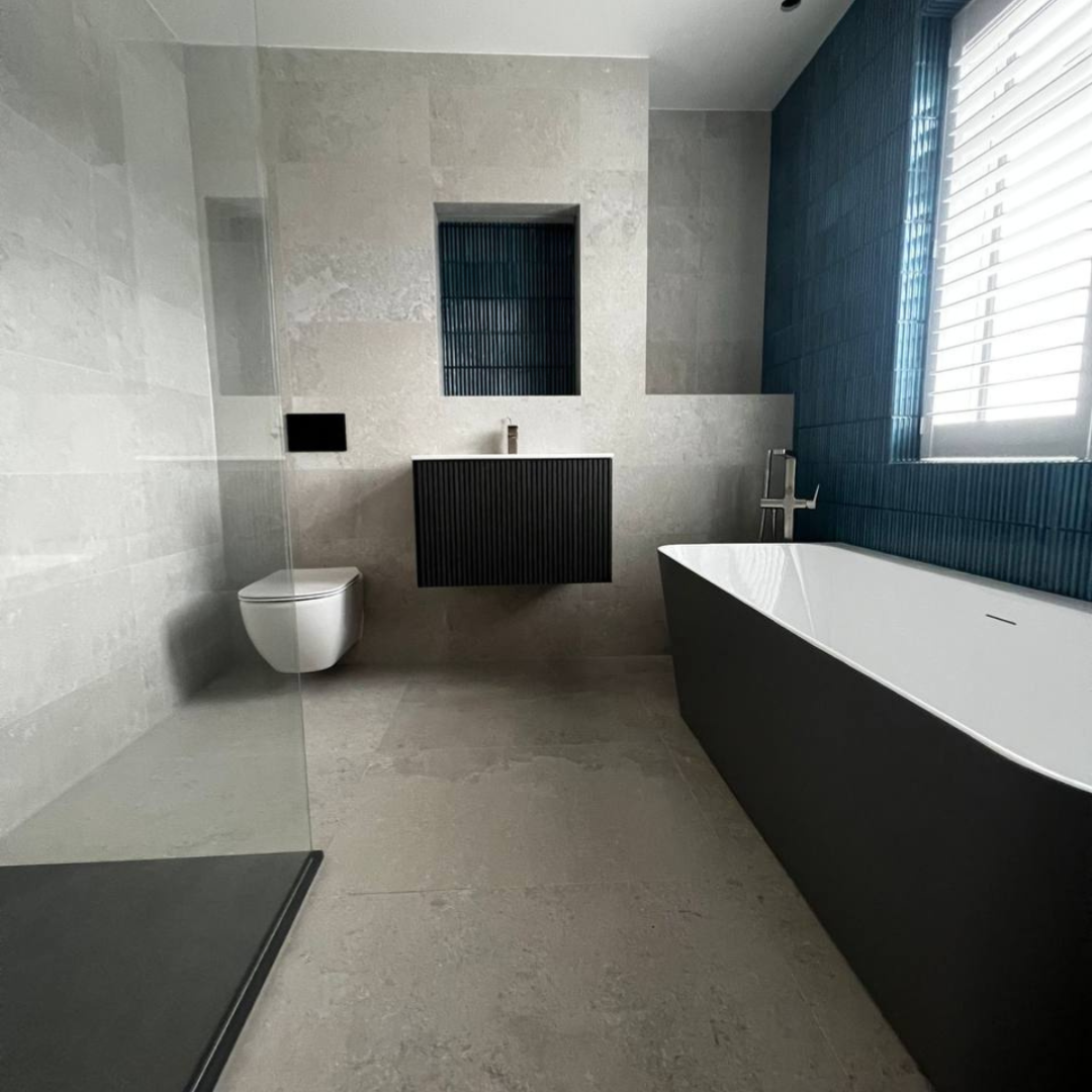 Barnet bathroom after — finished with stone tiling, freestanding bath and walk-in shower